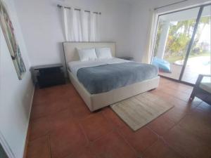波托韦洛Entire Villa with pool in front of beach!的一间带床和大窗户的卧室