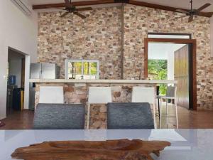 波托韦洛Entire Villa with pool in front of beach!的厨房设有石墙和桌椅