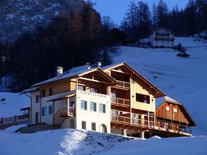 a building on a snow covered hill with snow at Apartments Serghela in San Cassiano