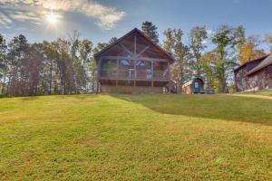 una casa en una colina con un gran campo de hierba en 1 Mi to Current River Sunset-View Van Buren Cabin, en Van Buren