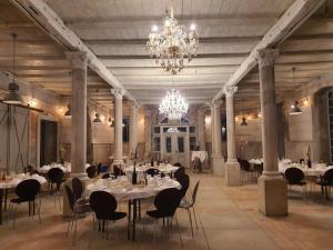 a dining room with tables and chairs and a chandelier at Gutshofblick XL in Hanshagen