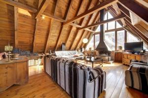 un soggiorno con divani e una grande finestra di Chalet Aranés Santa María cerca de Baqueira-Beret by Eth Flòc a Tredós