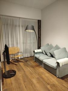 ein Wohnzimmer mit einer Couch und einer Lampe in der Unterkunft LOFT LA Santander Centro in Santander