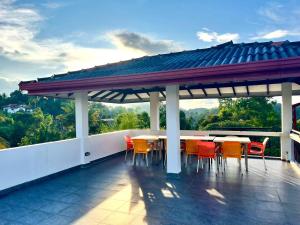 a patio with tables and chairs on a roof at Sky Bliss By Mahaweli in Kandy