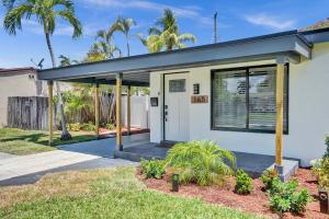 a house with a porch with palm trees at Palmpano Oasis, Heaven on Earth! Heated Pool! in Pompano Beach