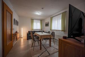 a living room with a dining table and a television at Ruhezone in Steinpleis