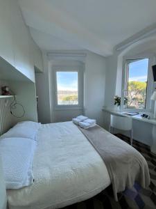a bedroom with a bed and a sink and two windows at About Italy Holiday Rooms and Apartments in Portovenere