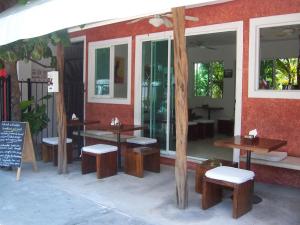 un groupe de tables et de bancs à l'extérieur d'un restaurant dans l'établissement Elements of the Island, à Isla Mujeres