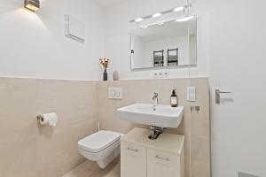 a white bathroom with a sink and a toilet at Primero Relax-Home I Premium Apartments ab 90qm I Balkon Garage I A8-Fuggerei in Augsburg