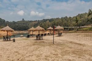un gruppo di sedie e ombrelloni su una spiaggia di Hotel Pietrasanta a Guatapé