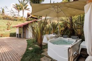 a bath tub sitting under an umbrella in a yard at Hotel Pietrasanta in Guatapé