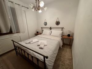 een slaapkamer met een bed met handdoeken erop bij Αύρα House in Arachova
