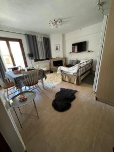 een woonkamer met een bed en een tafel bij Αύρα House in Arachova