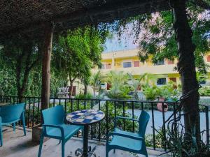 a table and chairs in front of a fence at Gallo Azul Hotel, en el corazón de Todos Santos in Todos Santos