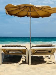 two beach chairs under an umbrella on the beach at Apartamento Aliciamin in Costa Calma