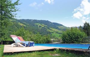 einen Stuhl auf einer Holzterrasse neben einem Pool in der Unterkunft Ferienhaus - Westendorf in Westendorf + 18 Fotos