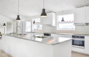 a kitchen with white cabinets and a stainless steel sink at Stunning Home In Gilleleje With Sauna in Gilleleje