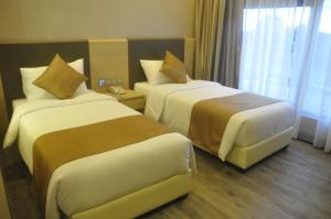 a hotel room with two beds and a window at Geobay Hotel in Johor Bahru