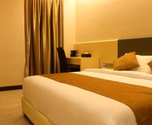 a hotel room with a bed and a desk at Geobay Hotel in Johor Bahru