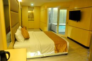 a bedroom with a large bed and a bathroom at Geobay Hotel in Johor Bahru