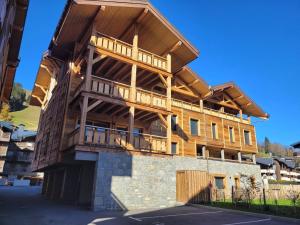 a large wooden building with a wrap around deck at Appartement cosy pour 6 aux Gets avec WIFI et terrasse - FR-1-598-154 in Les Gets