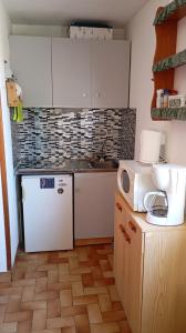 a kitchen with a white refrigerator and a microwave at Studio Plage 200m Parking gratuit Port la Nouvelle in Port-la-Nouvelle