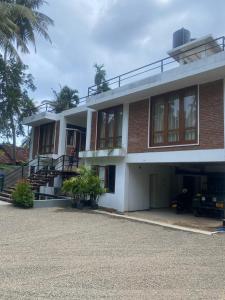 a large brick building with palm trees in front of it at KoLac Villa in Elagawagoda