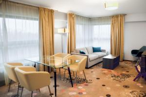 a living room with a glass table and chairs at Hotel Szafran in Czeladź +53 photos