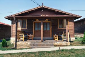a small wooden house with a porch and a patio at Къщи за гости БРИК in Sapareva Banya