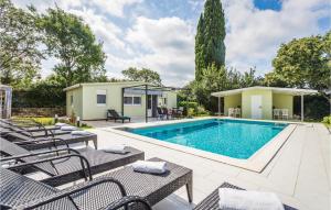 basen z meblami ogrodowymi obok domu w obiekcie Gorgeous Home In Rovinj w Rovinj