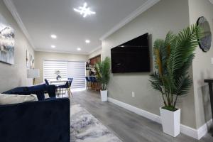 a living room with a blue couch and a tv at Walk to Stadium - 3BR King Bed Haven - Parking in Miami Gardens