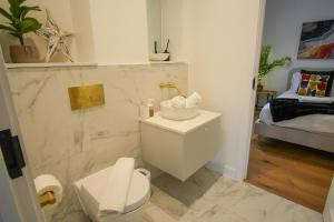 a bathroom with a sink and a toilet and a bed at SUNRISE 1 Bedroom Apartment in Central Eastbourne in Eastbourne +11 photos