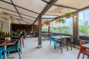 a restaurant with tables and chairs and windows at Hotel Heritage in Sao Paulo