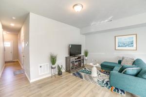 a living room with a blue couch and a tv at 10 Mi to Grand Rapids Modern Townhome! in Kentwood