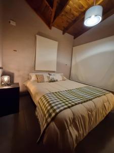 een slaapkamer met een bed met een geruite deken bij Moderno Duplex 1 - Complejo Las Cerezas in Esquel