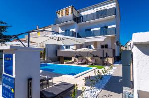 une villa avec une piscine et un bâtiment dans l'établissement Apartments Sunny Sky, à Vodice