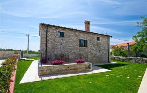 a stone house with flowers in a yard at Villa Luca in Radetići +49 photos
