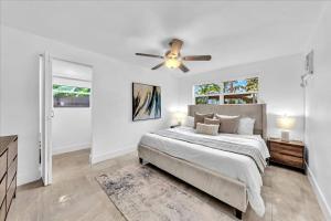 a white bedroom with a bed and a ceiling fan at Sunny Days Getaway, 5BD Heated Pool Family Home! in Fort Lauderdale +39 photos