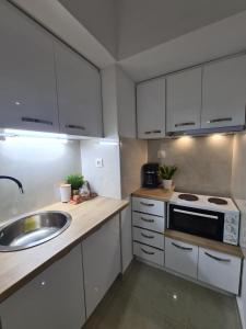 eine Küche mit weißen Schränken und einer Spüle in der Unterkunft Apartment in the heart of the city 5G in Larisa
