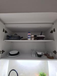 ein Regal mit Geschirr und anderen Küchenutensilien darauf in der Unterkunft Apartment in the heart of the city 5G in Larisa + 2 Fotos