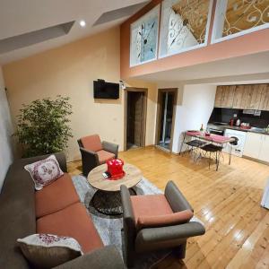 ein Wohnzimmer mit Sofa, Stühlen und einem Tisch in der Unterkunft Center Apartments The Quiet Luxury 7 in Plowdiw