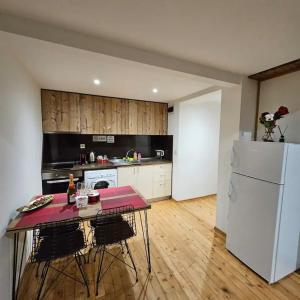 eine Küche mit einem Tisch und einem weißen Kühlschrank in der Unterkunft Center Apartments The Quiet Luxury 7 in Plowdiw