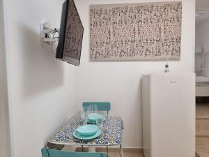 a table with a chair and a refrigerator in a room at Domus Deva in Cefalù