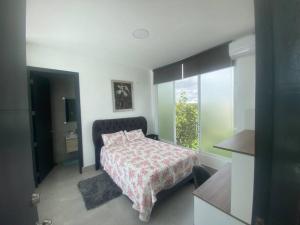 Un dormitorio con una cama y una ventana grande. en Casa Herradura H8-5, en Santa Elena