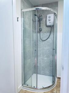 a shower with a glass door in a bathroom at Ivy Cottage Two Bedroom & Garden in Temple Fortune in London