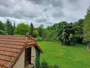 a building with a bird on the roof of a field at La Maisonnée in Marolles