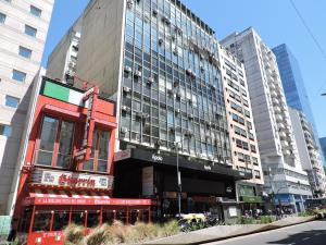 un grand bâtiment dans une ville avec de grands immeubles dans l'établissement 4 Ventanales sobre la Avenida Corrientes, à Buenos Aires