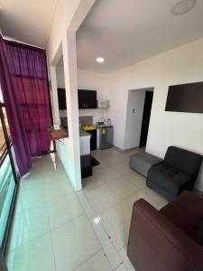 a living room with a couch and a kitchen at Espectacular Suite 801 Cumbres 12 in Guayaquil +3 photos