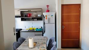 a small kitchen with a table and a refrigerator at Apê aconchegante in São José