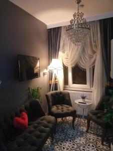 a living room with two chairs and a chandelier at Gürses Home in Edirne